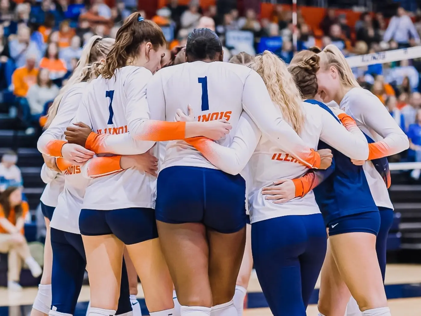 Illinois Women's Volleyball team huddling in uniform.