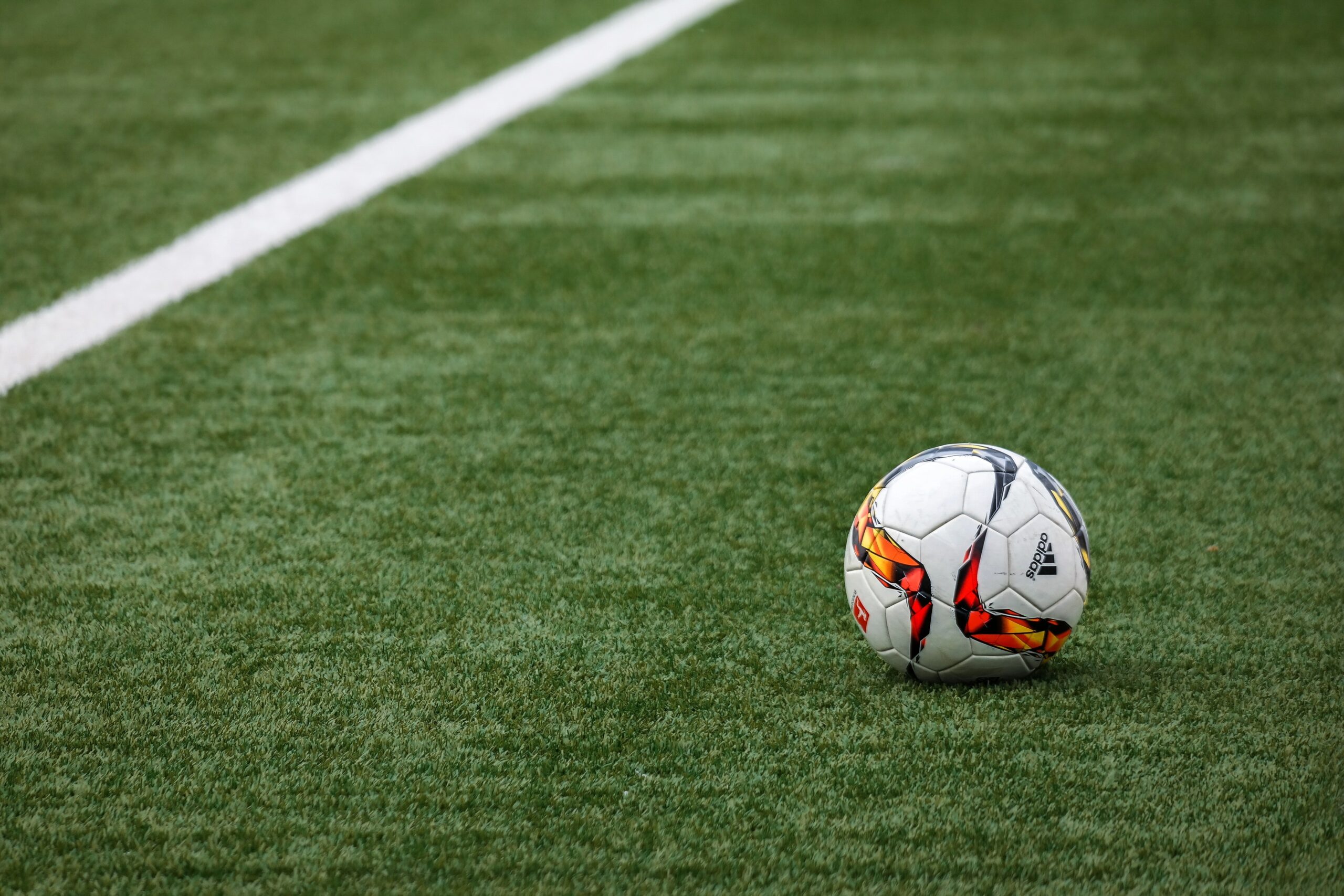 Stock photo of a soccer ball on a soccer pitch.