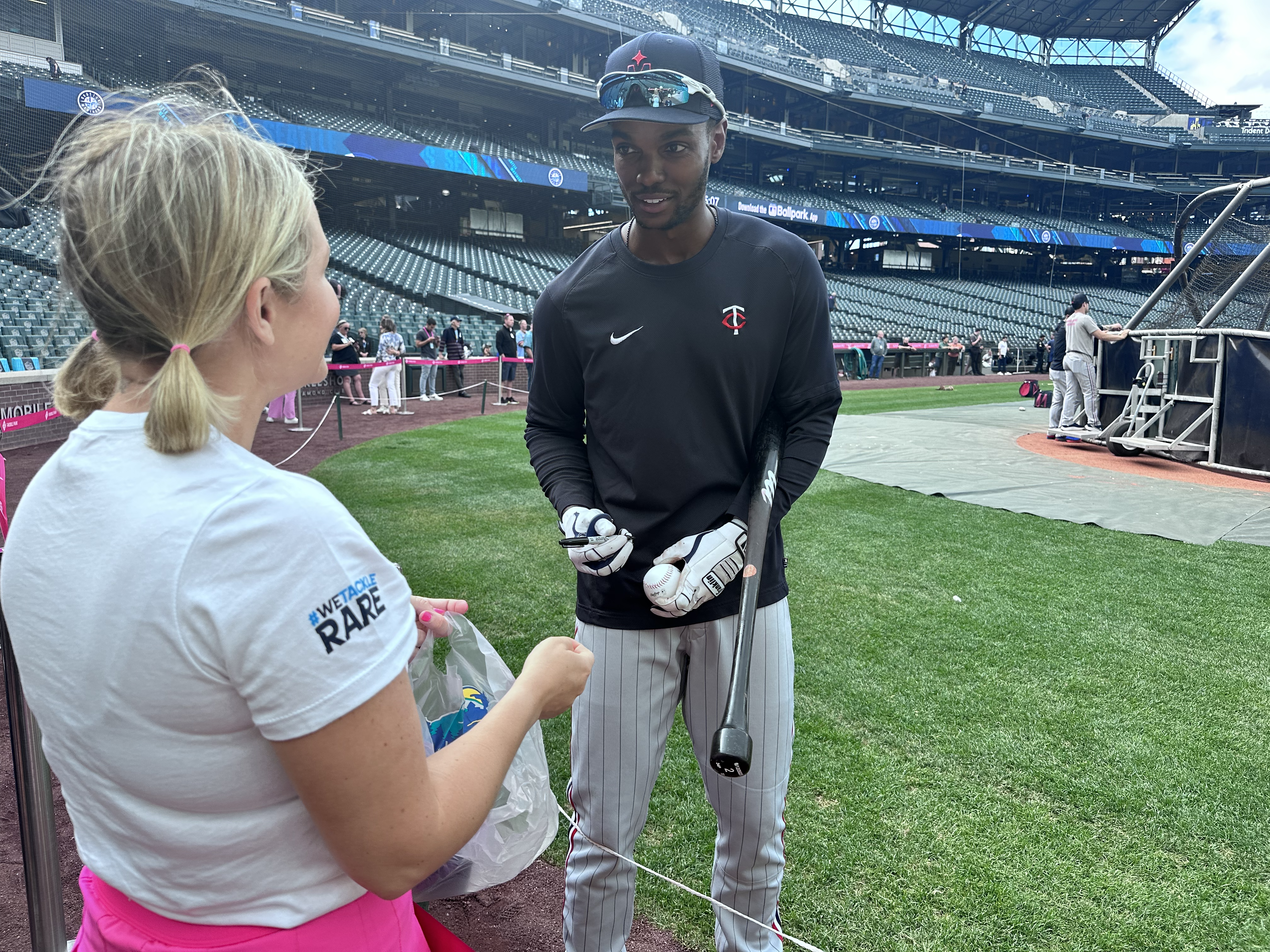 Photograph of Michael A. Taylor signing a baseball for a Uplifting Experience participant