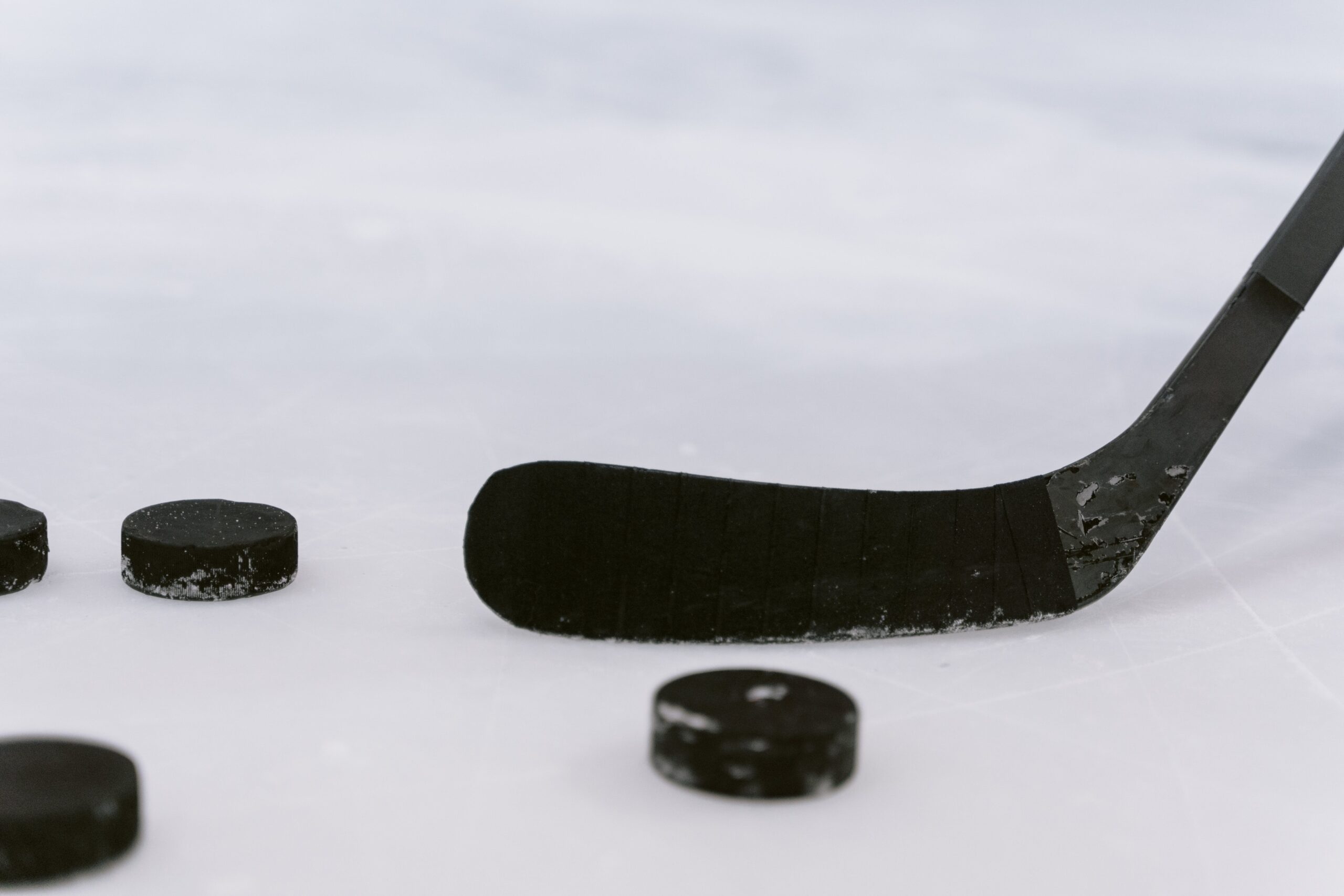 Generic photo of hockey puck and stick on ice