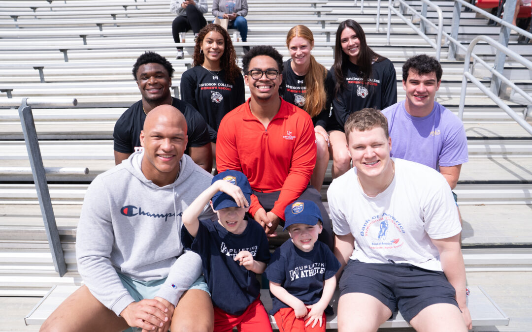 Davidson Women's soccer and football chapter leaders attend a Davidson women's soccer game with families impacted by rare diseases.